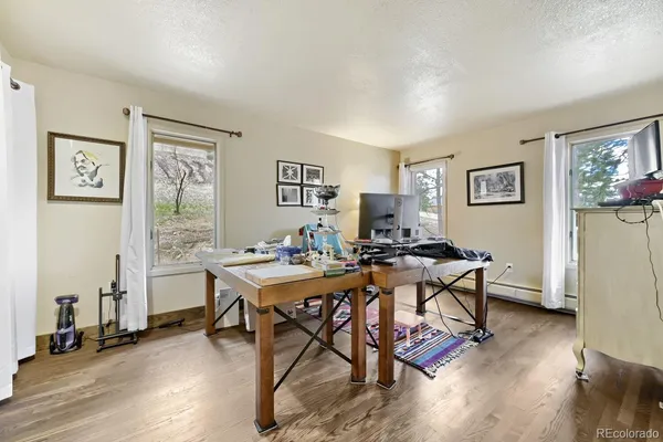 a view of a workspace with furniture window and wooden floor