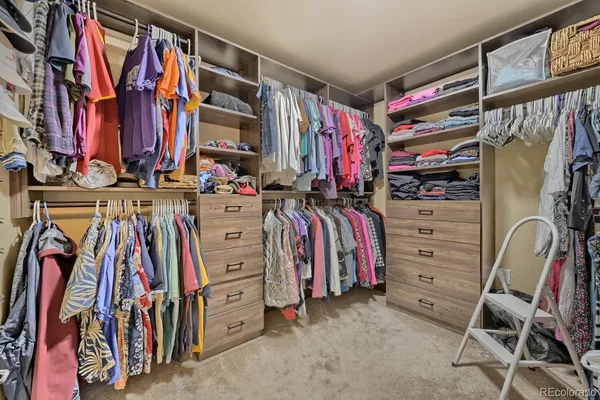 a view of walk in closet with clothes