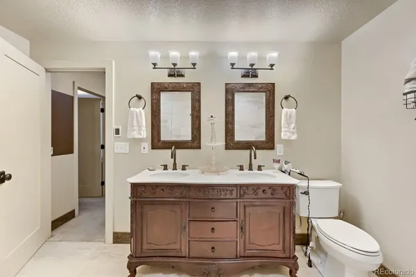 a bathroom with a double vanity sink and a toilet