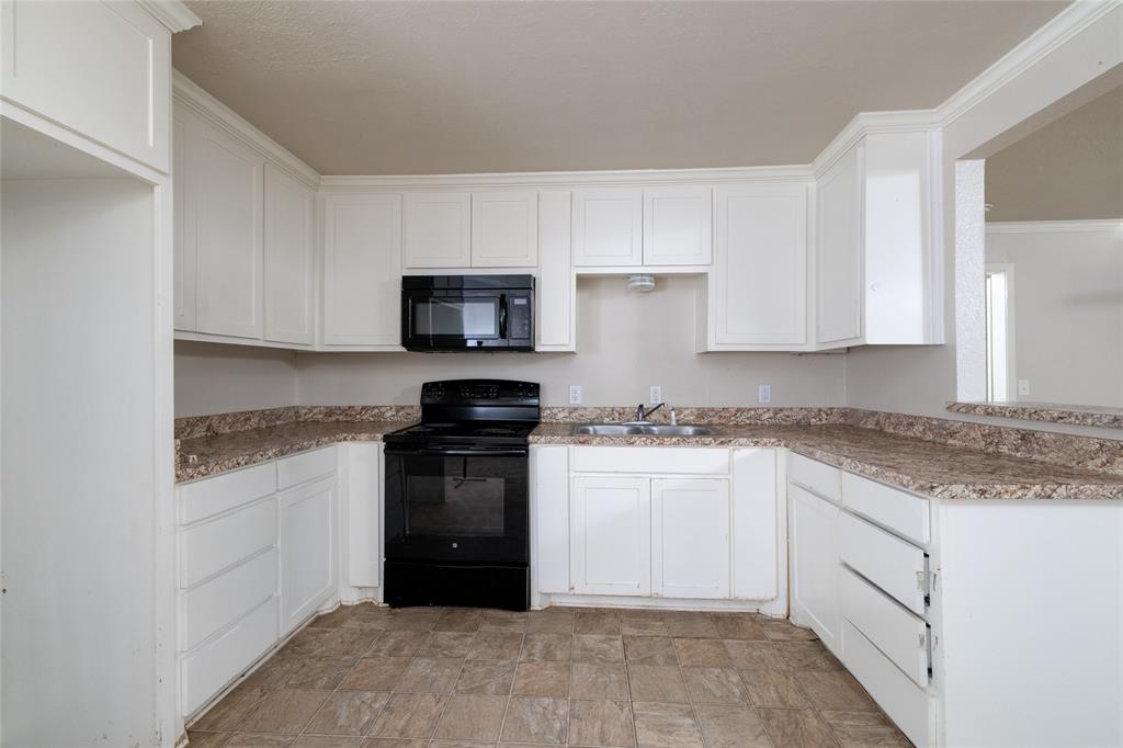 313 North Roe Street White Settlement, TX 76108 - Photo 10 of 33 Kitchen featuring white cabinetry with crown molding, laminate countertops, stainless steel sink, black range, and built-in microwave