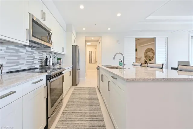 a kitchen with stainless steel appliances granite countertop a lot of counter space and wooden floors