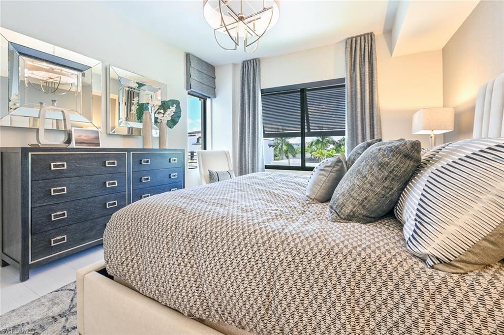 1111 Central Avenue, Unit 303 Naples, FL 34102 - Photo 19 of 50 a bedroom with a large bed and a large mirror on dresser and a large window