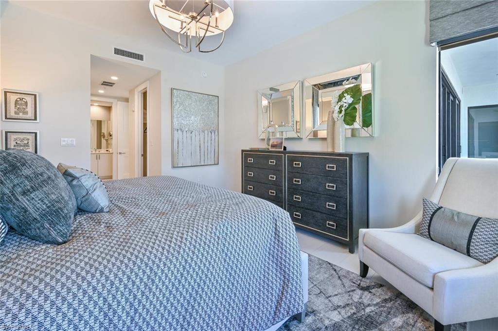1111 Central Avenue, Unit 303 Naples, FL 34102 - Photo 20 of 50 a bedroom with a bed and wooden floor