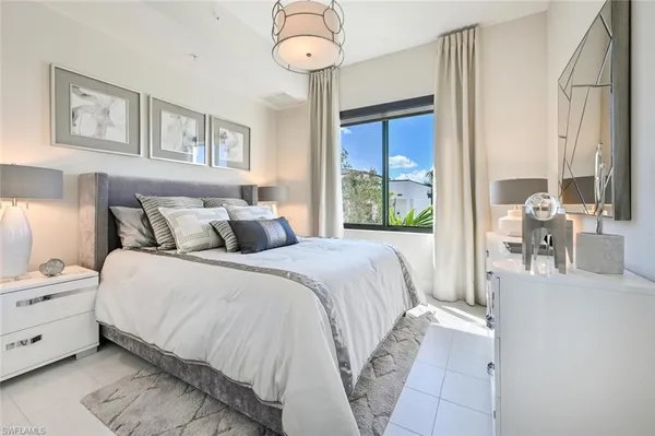 a bedroom with a large bed and a chandelier