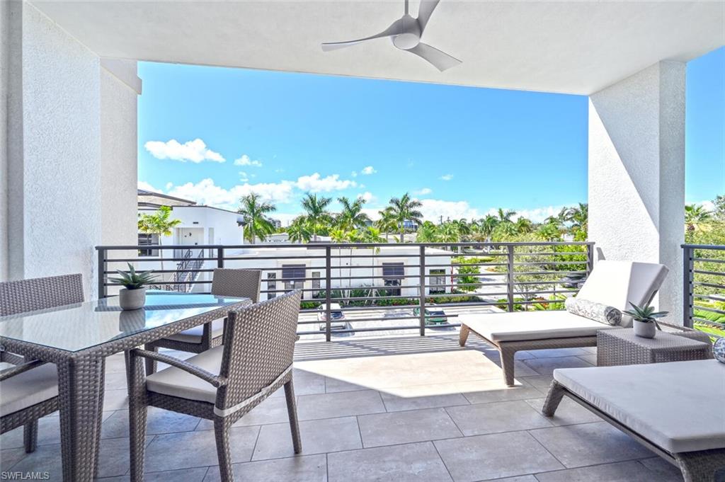1111 Central Avenue, Unit 303 Naples, FL 34102 - Photo 26 of 50 a living room with patio furniture and a floor to ceiling window