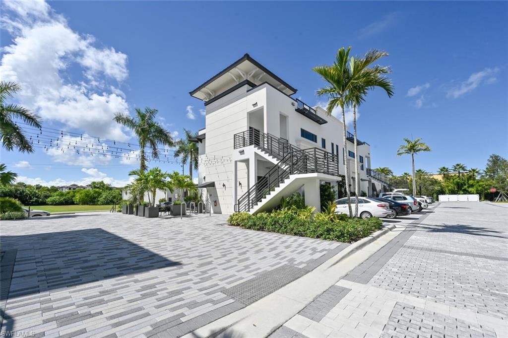 1111 Central Avenue, Unit 303 Naples, FL 34102 - Photo 41 of 50 a front view of a house with a yard and garage