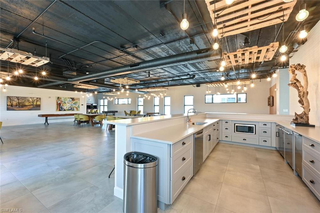 1111 Central Avenue, Unit 303 Naples, FL 34102 - Photo 43 of 50 a large white kitchen with kitchen island a stove a sink and a dishwasher