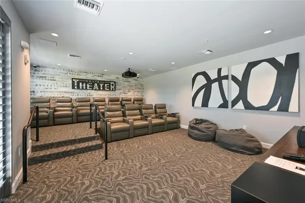 a view of a room with kitchen island stainless steel appliances refrigerator stove and wooden floor