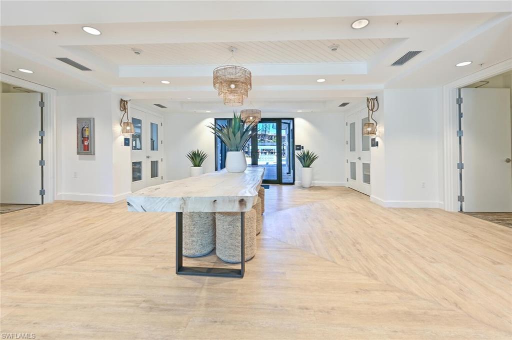 1111 Central Avenue, Unit 303 Naples, FL 34102 - Photo 48 of 50 a view of a room with kitchen island stainless steel appliances refrigerator stove and wooden floor