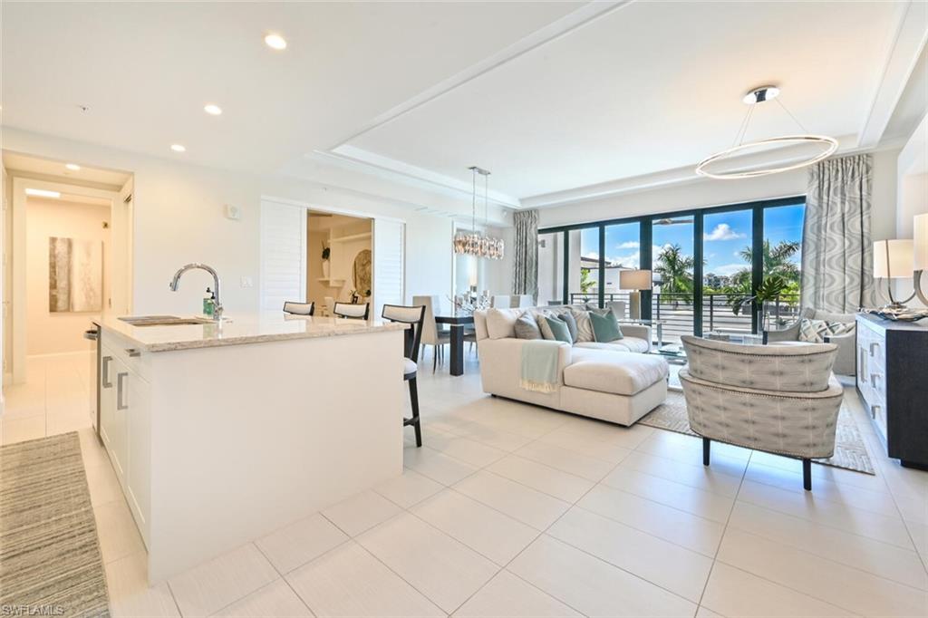1111 Central Avenue, Unit 303 Naples, FL 34102 - Photo 5 of 50 a living room with couches and a dining table with wooden floor