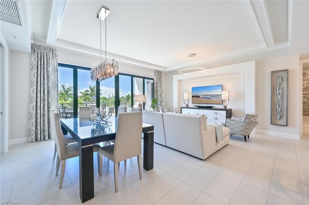 1111 Central Avenue, Unit 303 Naples, FL 34102 - Photo 6 of 50 a dining room with furniture a chandelier and fireplace
