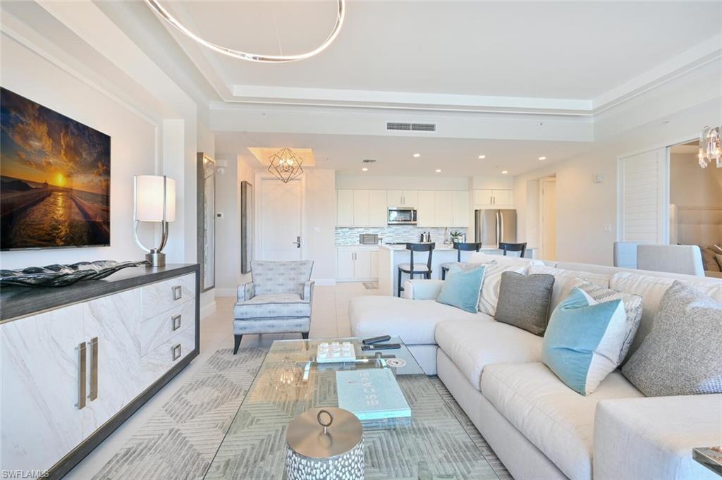 1111 Central Avenue, Unit 303 Naples, FL 34102 - Photo 9 of 50 a living room with furniture and a flat screen tv