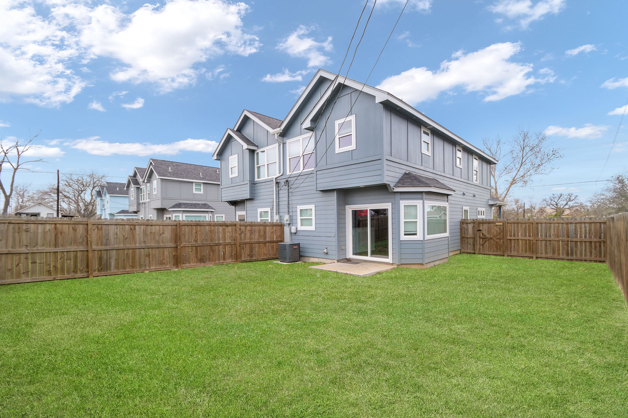 1008 East Fannin Street Luling, TX 78648 - Photo 3 of 13 Rear view of property featuring a fenced backyard, board and batten siding, and a patio area