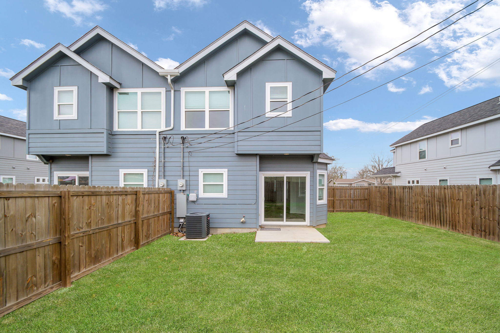 1008 East Fannin Street Luling, TX 78648 - Photo 4 of 13 Rear view of house with a fenced backyard and board and batten siding