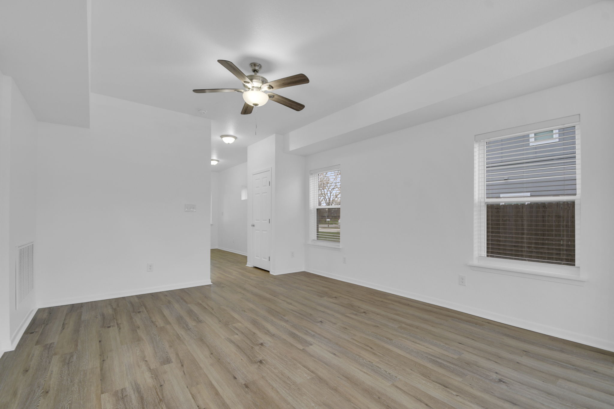 1008 East Fannin Street Luling, TX 78648 - Photo 9 of 13 Unfurnished room with light wood-style floors and ceiling fan