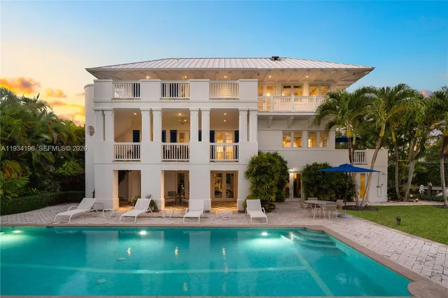 a view of a swimming pool with a yard and palm trees