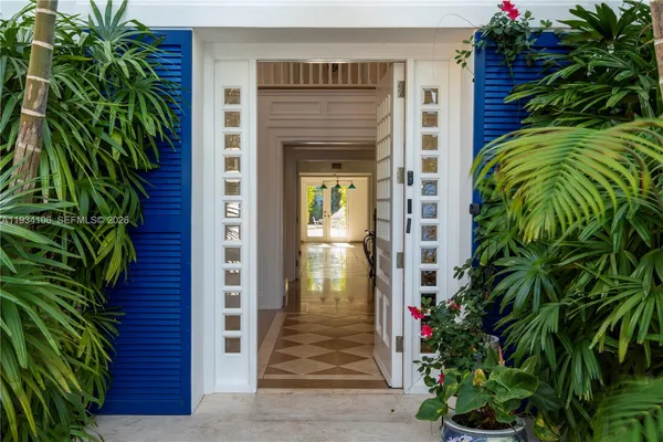a view of a house with a yard and potted plants