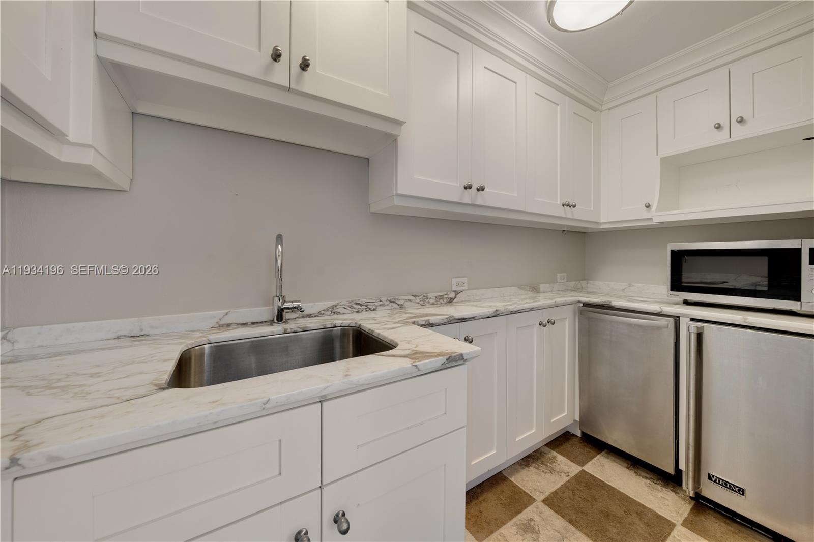 100 Cape Florida Drive Key Biscayne, FL 33149 - Photo 47 of 68 a kitchen with white cabinets and sink