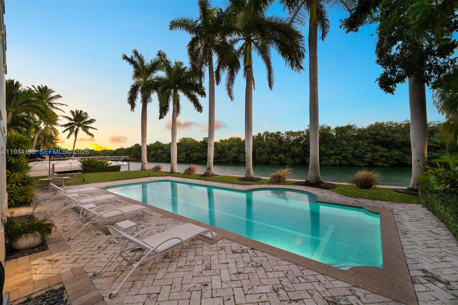 100 Cape Florida Drive Key Biscayne, FL 33149 - Photo 8 of 68 a view of a swimming pool with a yard and palm trees