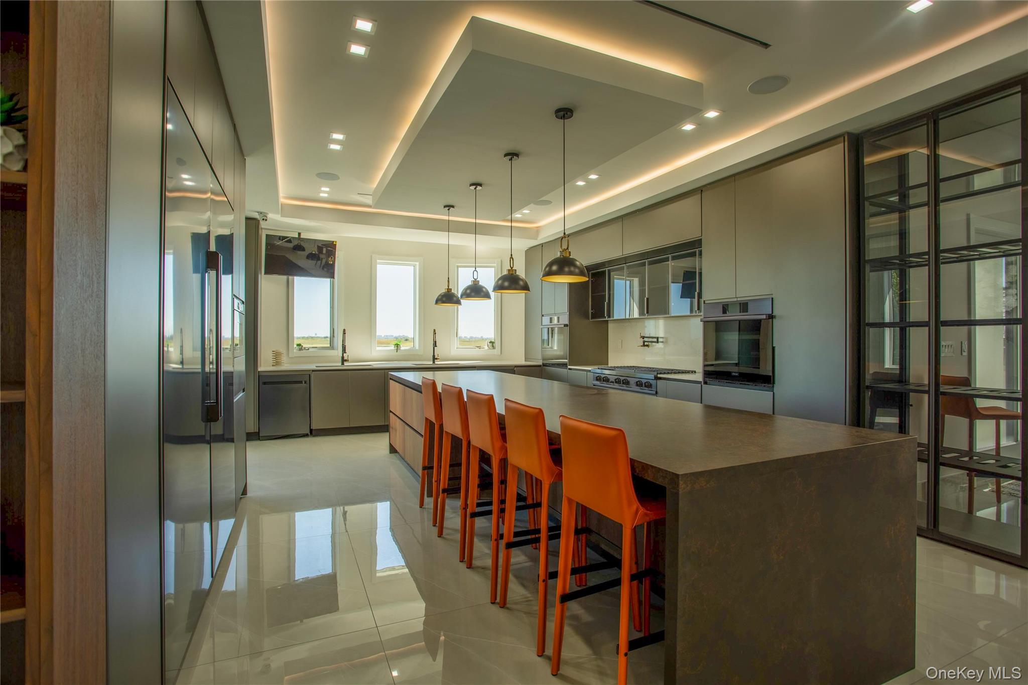 190 Curtis Road Woodmere, NY 11598 - Photo 11 of 45 Kitchen with a kitchen bar, decorative light fixtures, gray cabinetry, a large island, and modern cabinets