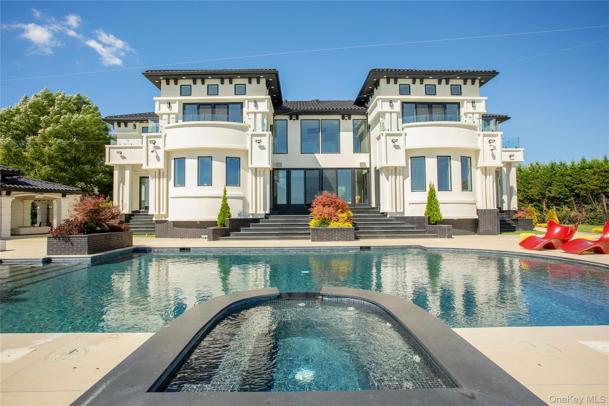 190 Curtis Road Woodmere, NY 11598 - Photo 2 of 45 Back of house with a pool with connected hot tub, a patio, and stucco siding