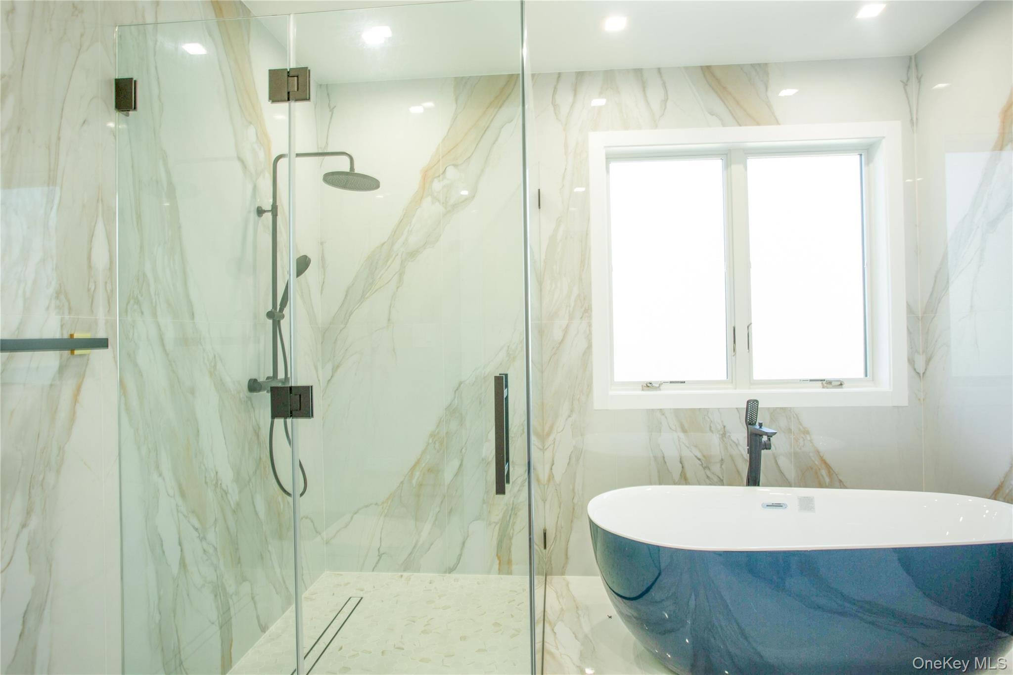 190 Curtis Road Woodmere, NY 11598 - Photo 21 of 45 Bathroom featuring a freestanding tub, a marble finish shower, stone wall, and recessed lighting