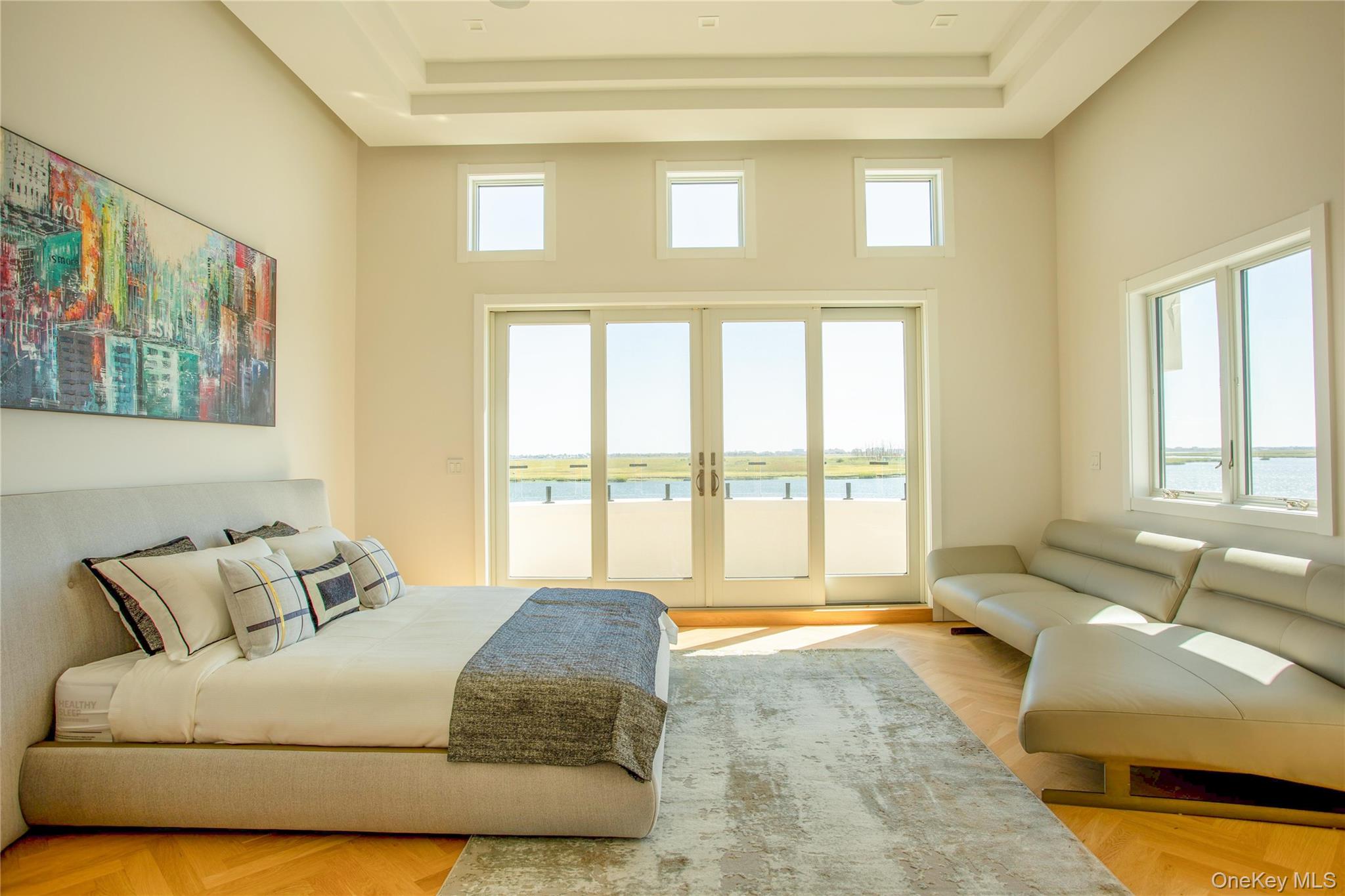 190 Curtis Road Woodmere, NY 11598 - Photo 25 of 45 Bedroom with a water view, access to outside, french doors, a raised ceiling, and a high ceiling