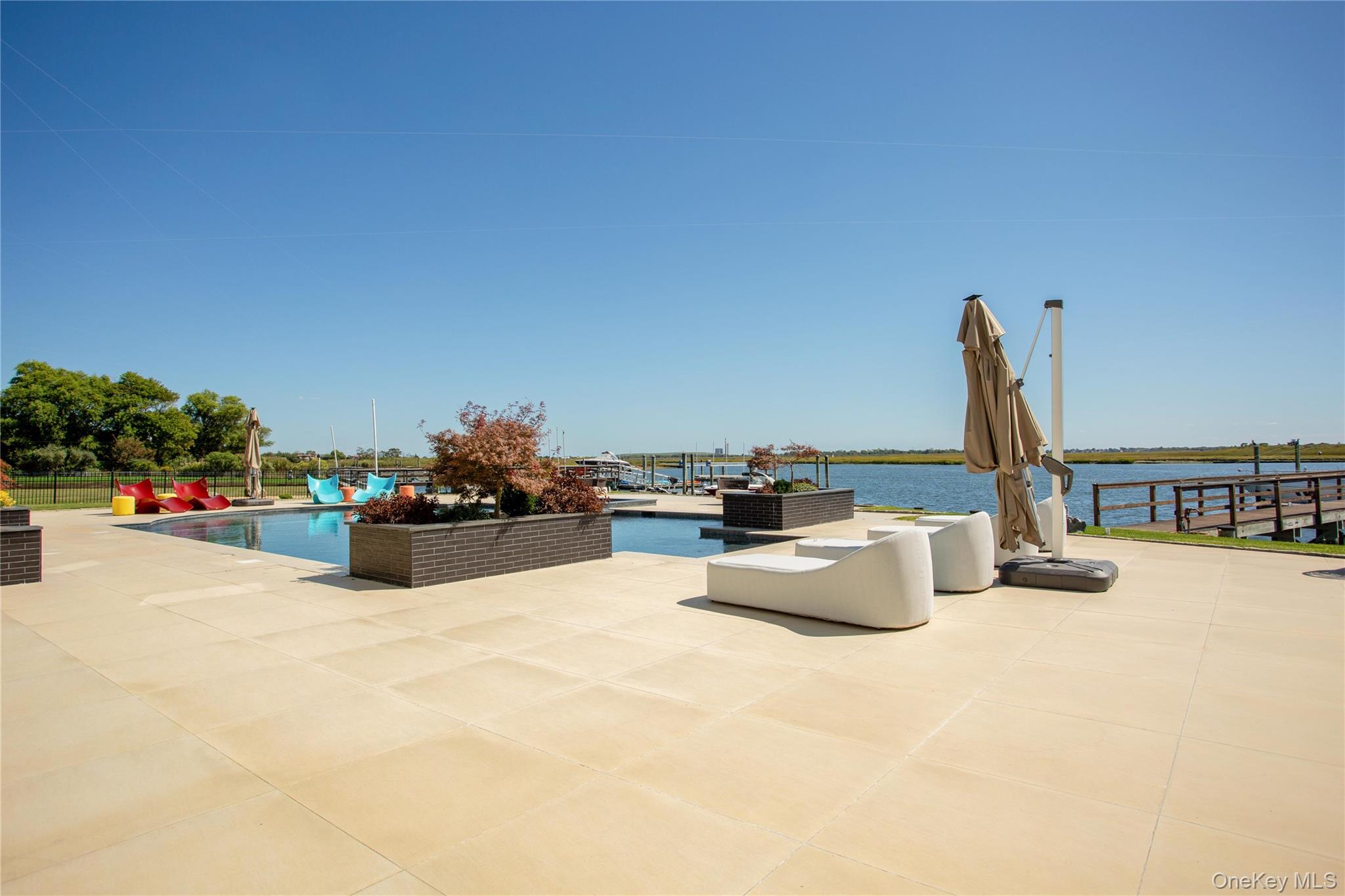 190 Curtis Road Woodmere, NY 11598 - Photo 36 of 45 View of patio featuring an outdoor pool and a water view