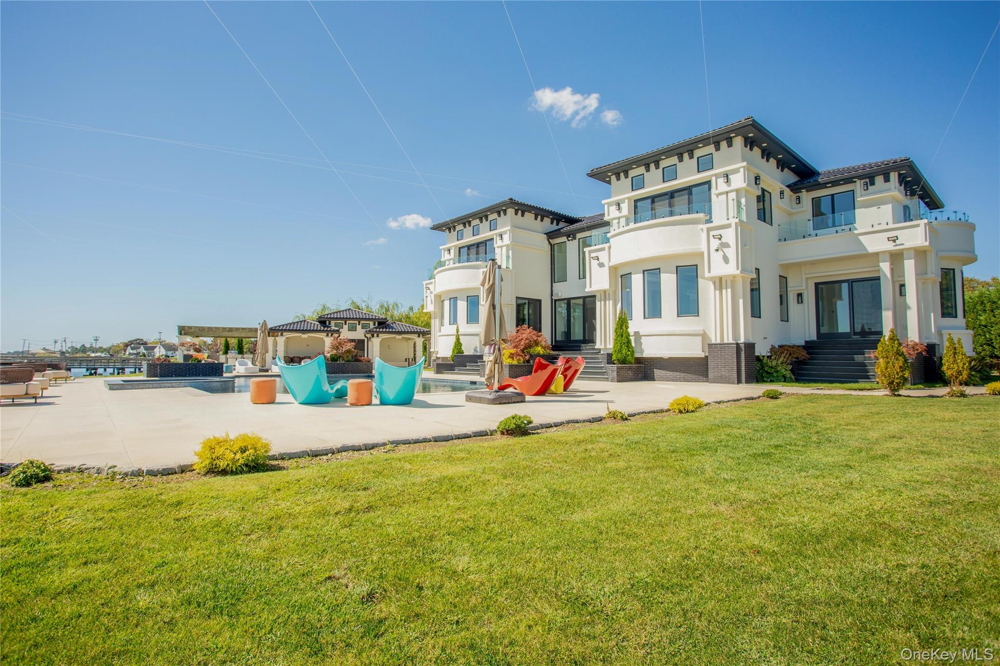 190 Curtis Road Woodmere, NY 11598 - Photo 39 of 45 Back of property with a swimming pool, a yard, stucco siding, and a patio area
