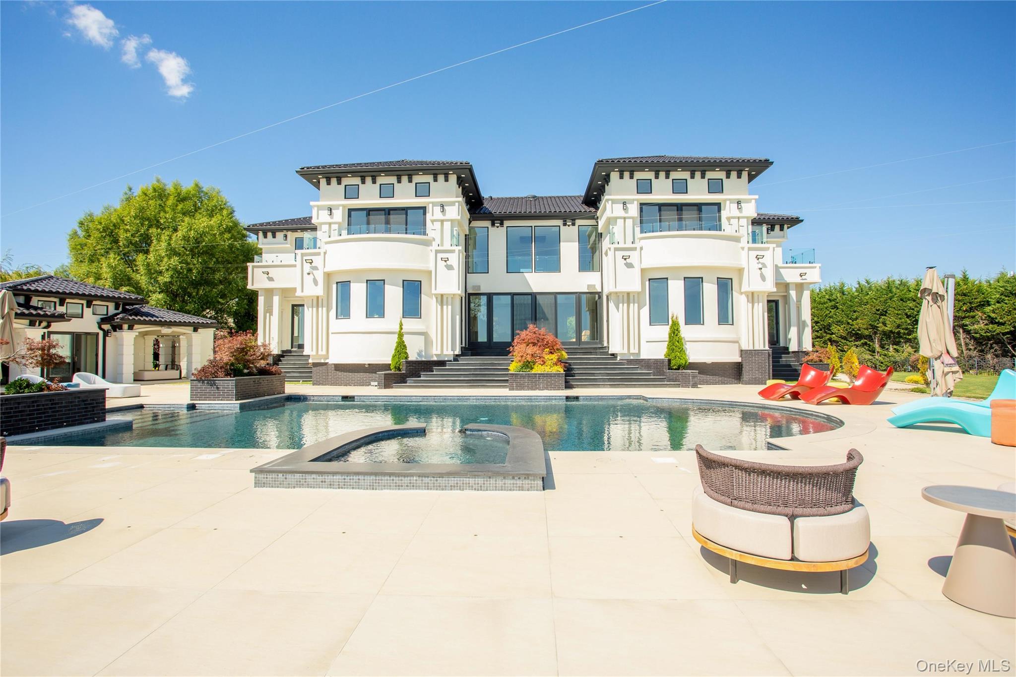 190 Curtis Road Woodmere, NY 11598 - Photo 40 of 45 Rear view of property with a patio, stucco siding, and a pool with connected hot tub