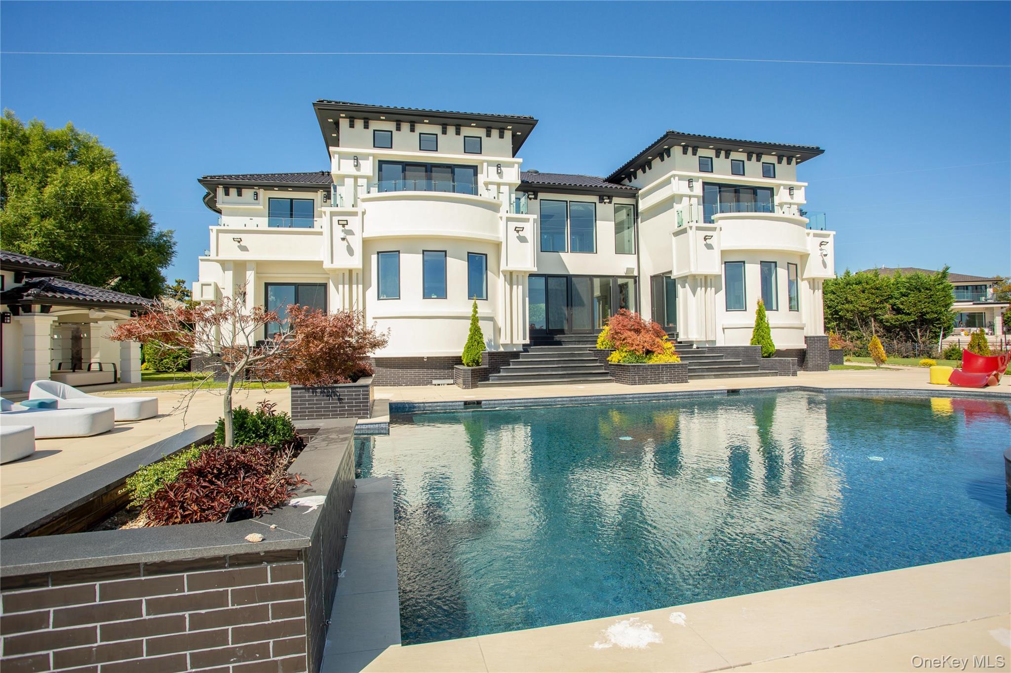 190 Curtis Road Woodmere, NY 11598 - Photo 41 of 45 Rear view of property featuring an outdoor pool, stucco siding, and a patio