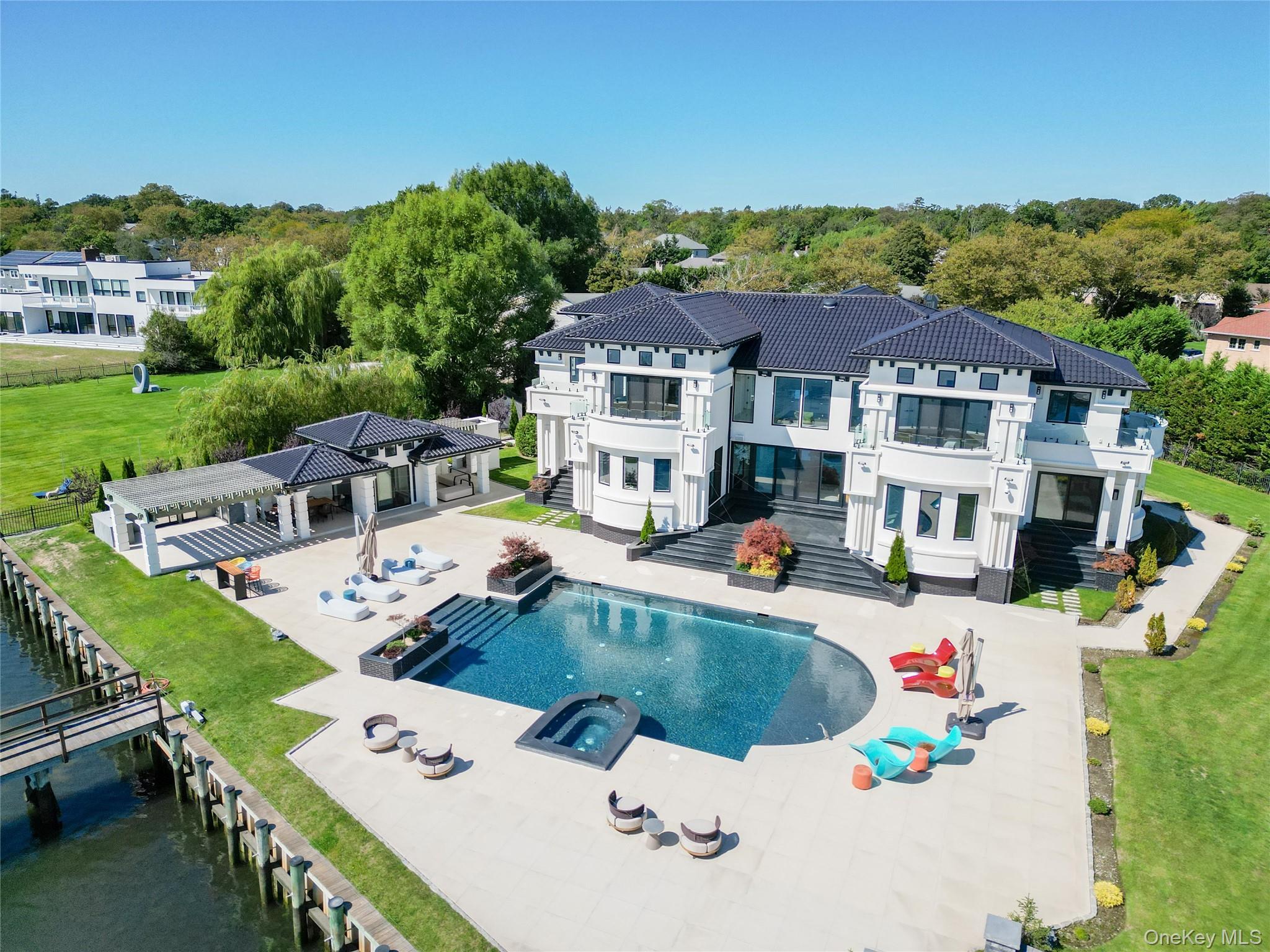 190 Curtis Road Woodmere, NY 11598 - Photo 44 of 45 Rear view of house featuring a patio area, a fenced backyard, a balcony, and a pool with connected hot tub