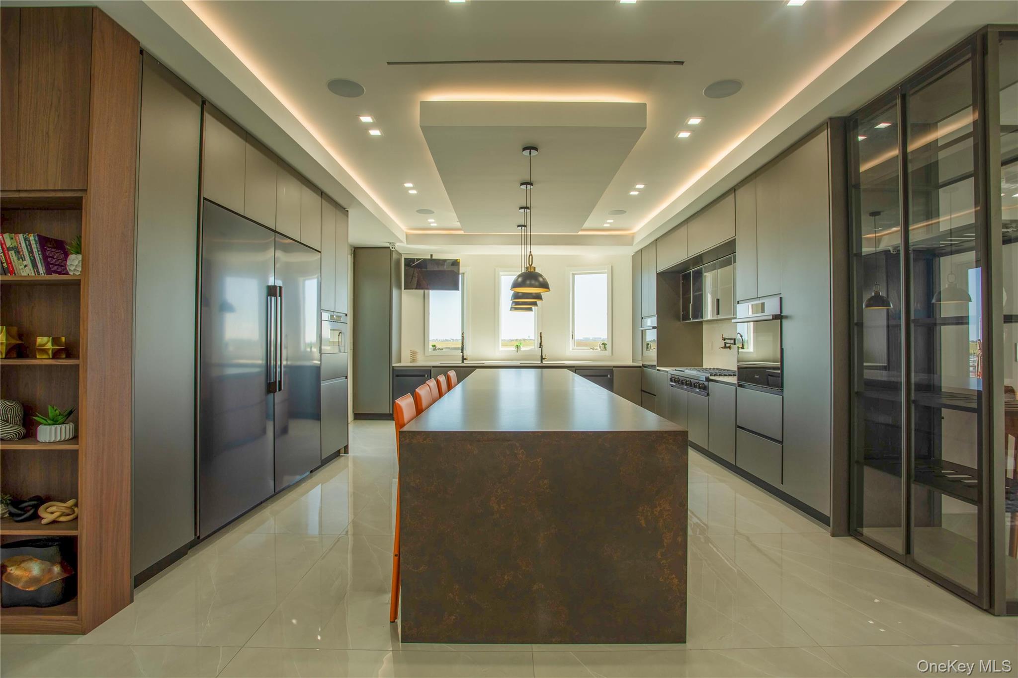 190 Curtis Road Woodmere, NY 11598 - Photo 10 of 45 Kitchen with a tray ceiling, modern cabinets, gray cabinets, stainless steel appliances, and a center island