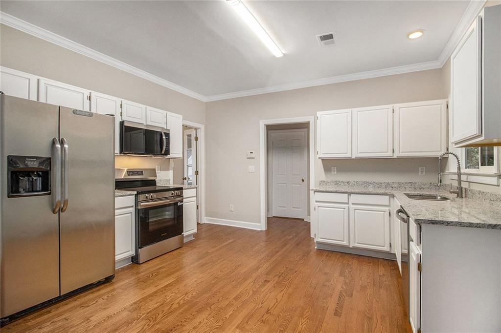 1463 Crescent Walk Decatur, GA 30033 - Photo 9 of 28 a kitchen with granite countertop a refrigerator and a stove top oven