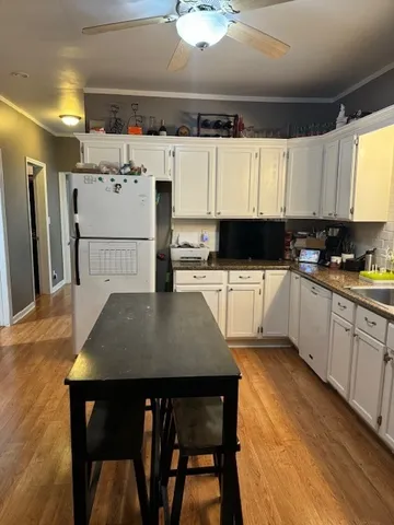 a kitchen with stainless steel appliances a white table chairs and a refrigerator