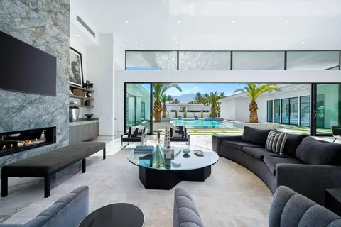 a living room with furniture a fireplace and a large window