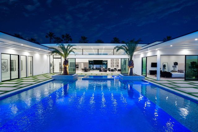 a living room with fireplace furniture and a dining table with kitchen view