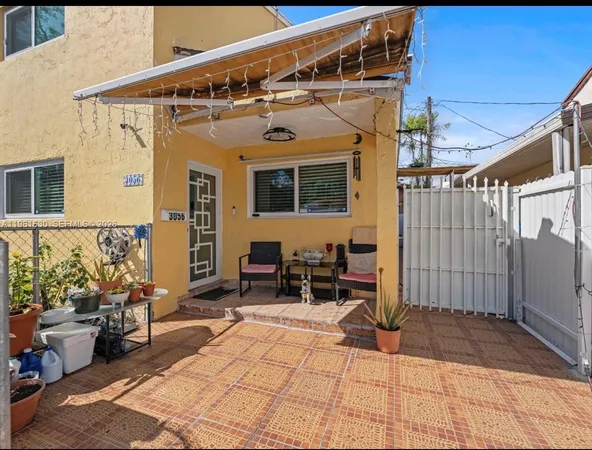 a view of a patio with table and chairs with wooden fence