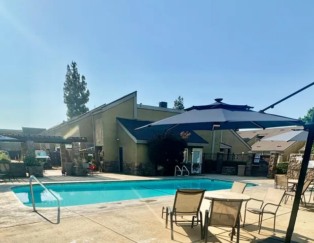 a view of a chairs and table in patio with a yard