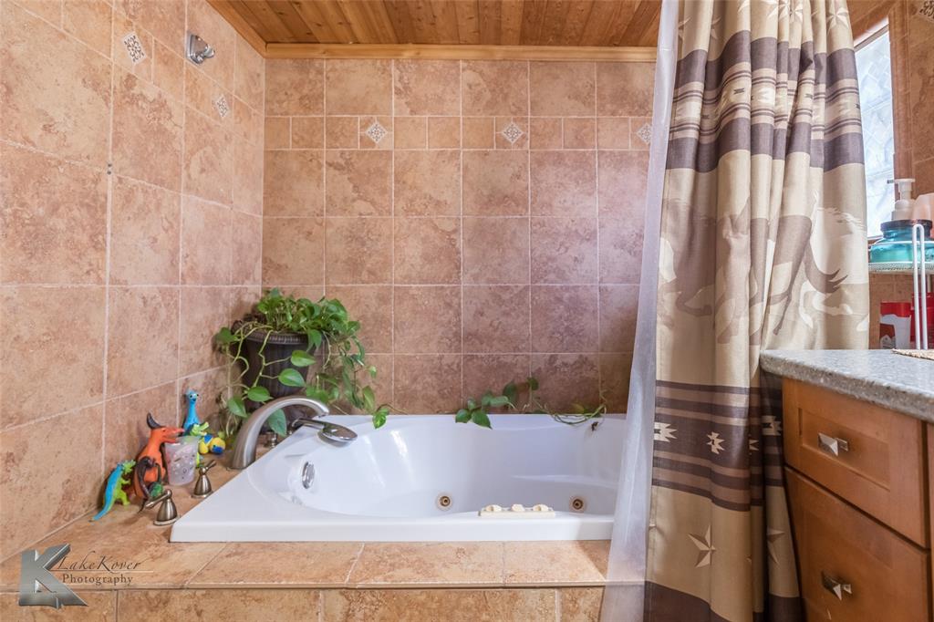10001 County Road 379 Hawley, TX 79525 - Photo 22 of 39 a bathroom with a bathtub and a shower