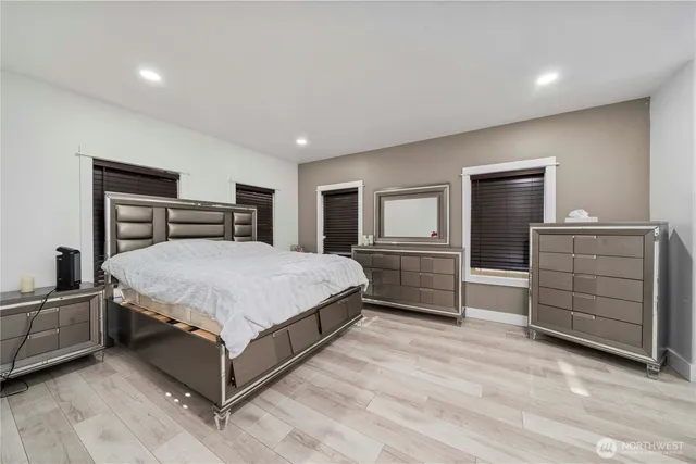 a spacious bedroom with a bed and a tv on a dresser