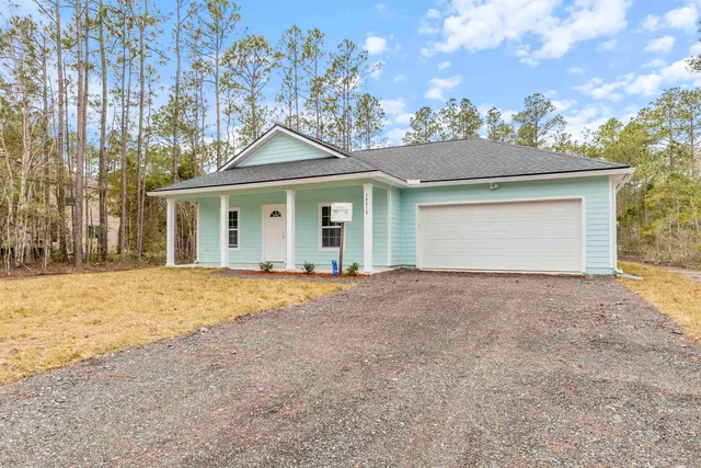 front view of a house with a yard and garage