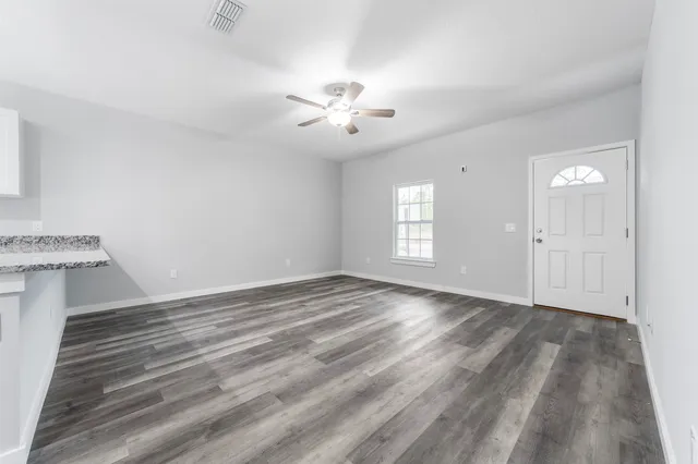 wooden floor in an empty room with a window