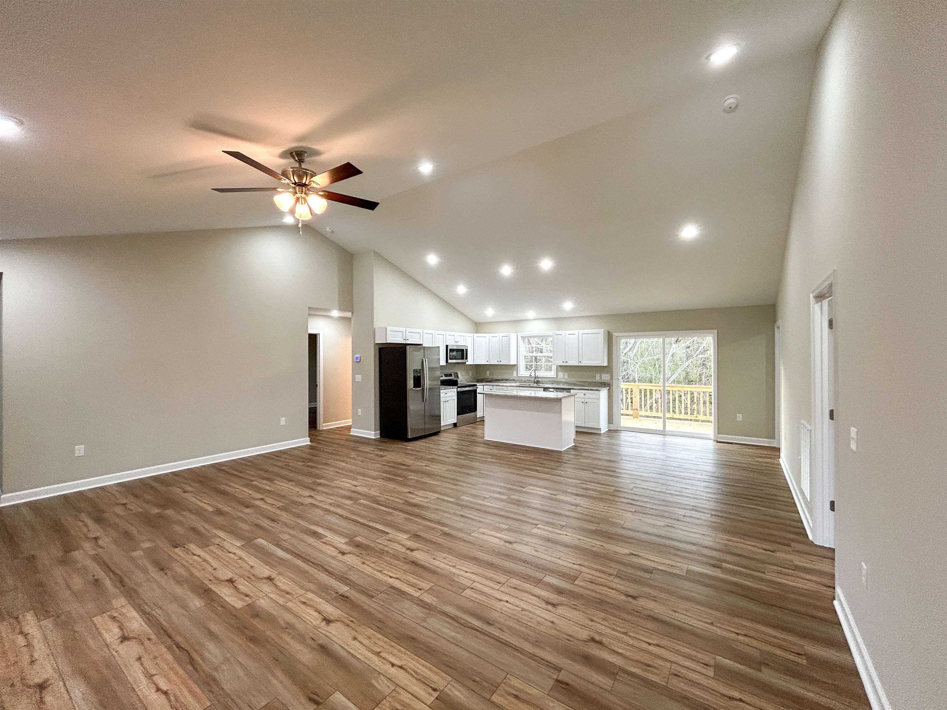 244 Locustdale Loop Shenandoah, VA 22849 - Photo 17 of 74 a view of an empty room with wooden floor and a kitchen