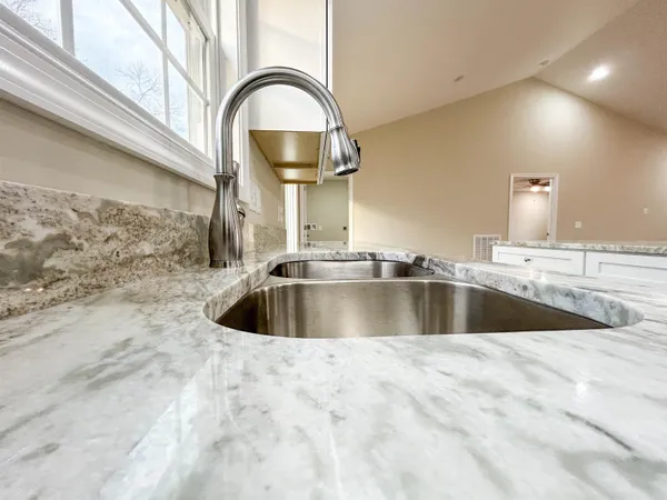 a bathroom with a granite countertop toilet a sink and a mirror