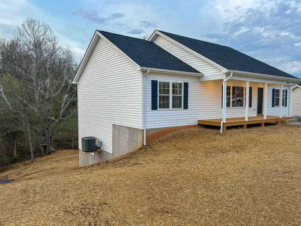 a view of a house with backyard and trees