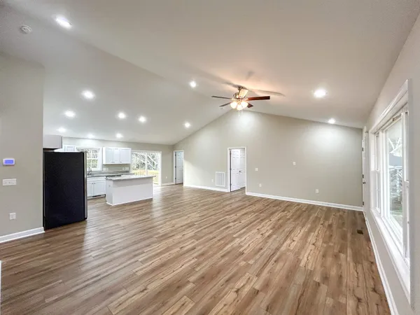 a kitchen with stainless steel appliances granite countertop a stove top oven a refrigerator a sink and dishwasher with wooden floor