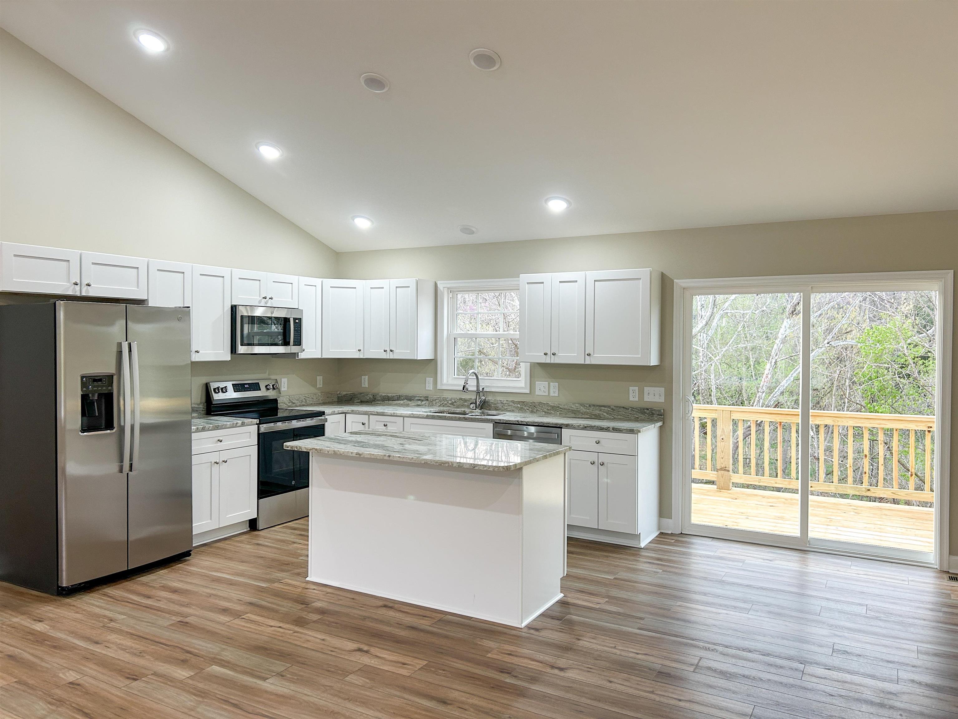 244 Locustdale Loop Shenandoah, VA 22849 - Photo 45 of 74 a kitchen with stainless steel appliances granite countertop a stove top oven a refrigerator a sink and dishwasher with wooden floor