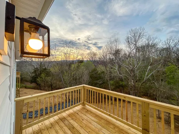 a view of balcony with wooden floor and fence