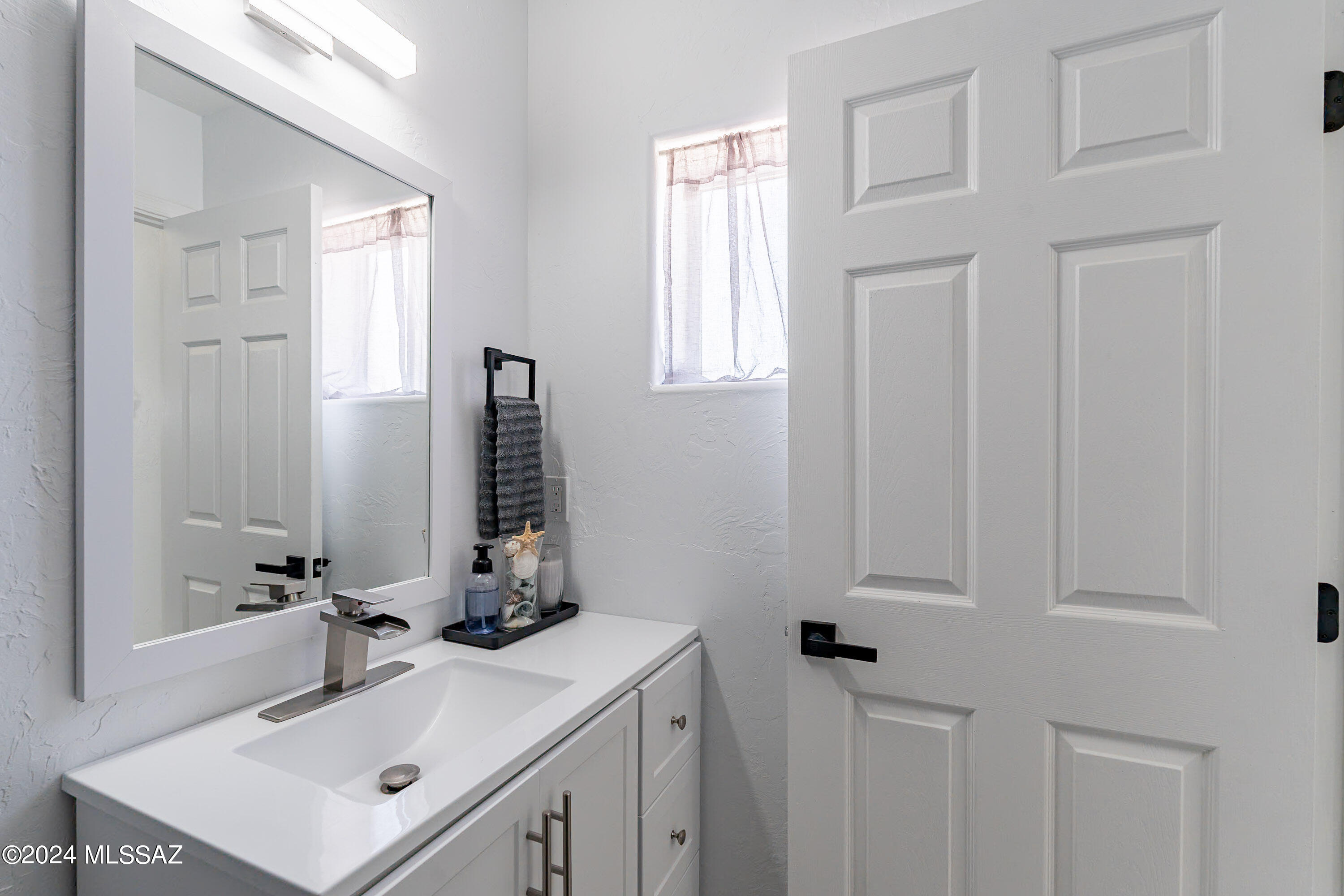 1009 Calle Coyote Rio Rico, AZ 85648 - Photo 20 of 28 a bathroom with a sink vanity and a mirror
